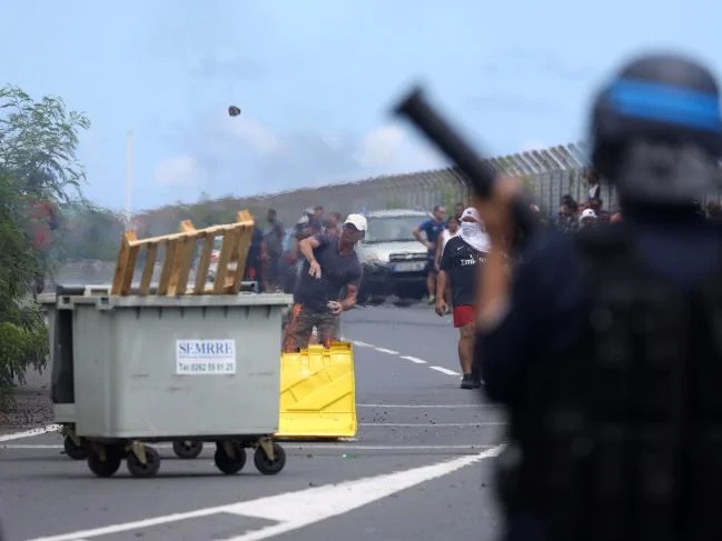 Đoàn người biểu tình ném đá, chai lọ. Ảnh: Richard Bouhet/AFP.