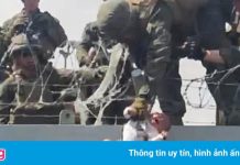 Trẻ em được chuyền qua rào kẽm gai ở sân bay Kabul