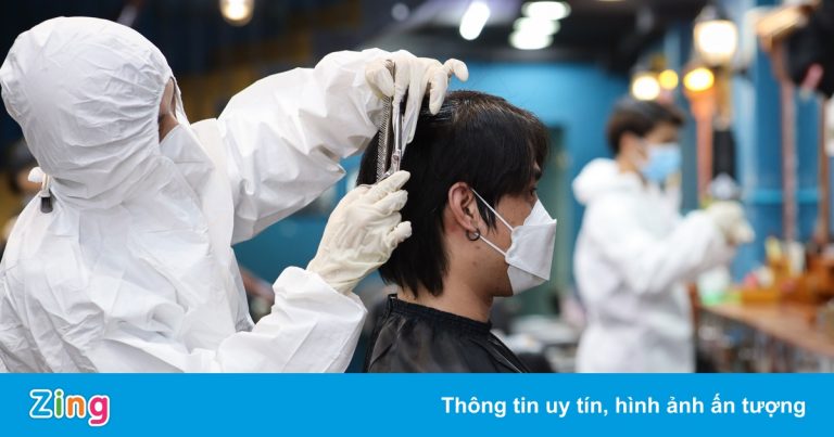 Thợ cắt tóc ở TP.HCM mặc đồ bảo hộ, chịu nóng để phòng dịch