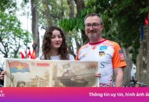 Chen chân nhận phụ san báo Nhân Dân mừng 50 năm thống nhất